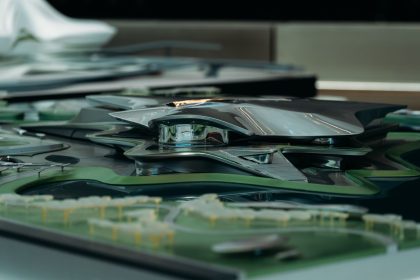 Modelo arquitetônico futurista de estrutura metálica inserida em uma área verde.