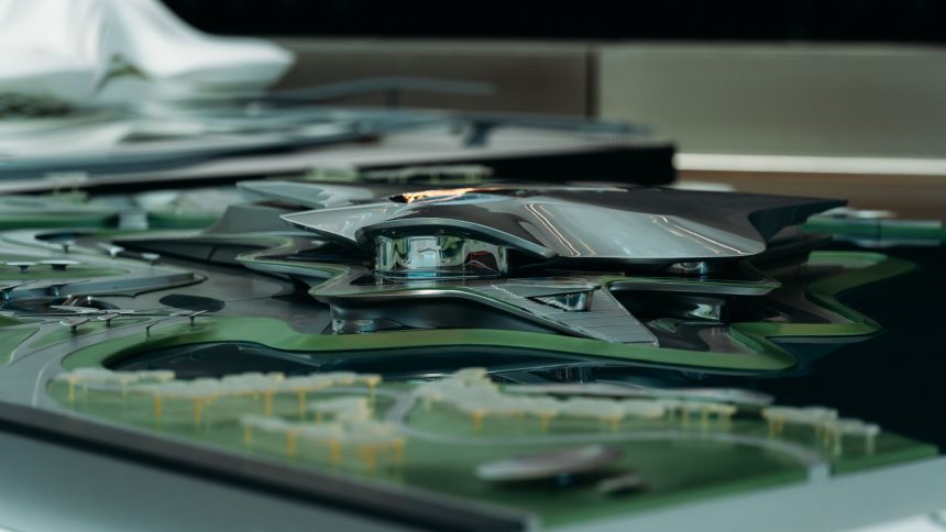 Modelo arquitetônico futurista de estrutura metálica inserida em uma área verde.